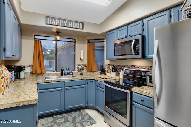 kitchen with blue cabinets, appliances with stainless steel finishes, sink, and light tile patterned floors