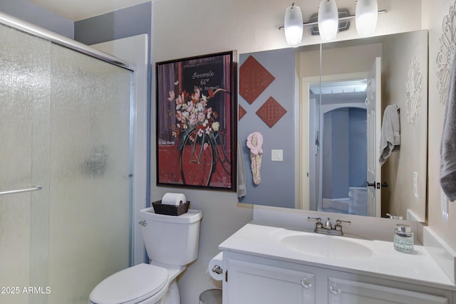 bathroom featuring vanity, toilet, and walk in shower