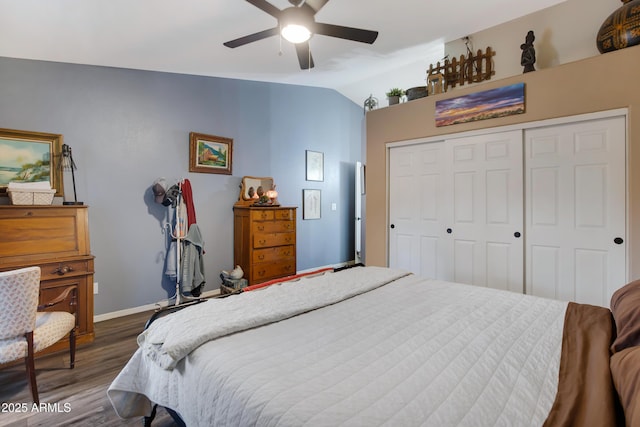 bedroom with dark hardwood / wood-style flooring, lofted ceiling, a closet, and ceiling fan