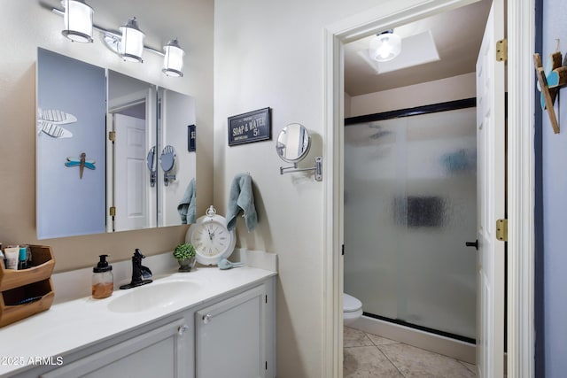 bathroom featuring an enclosed shower, vanity, tile patterned floors, and toilet