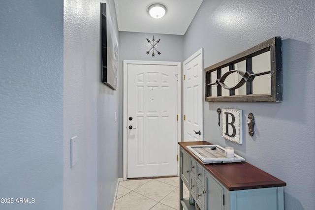 doorway to outside with light tile patterned floors