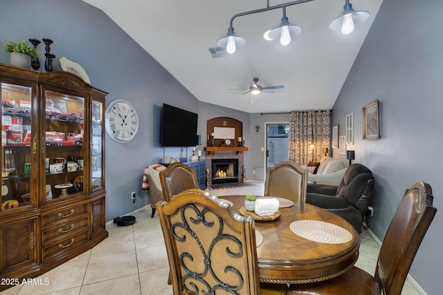 dining area featuring light tile patterned floors, vaulted ceiling, and ceiling fan