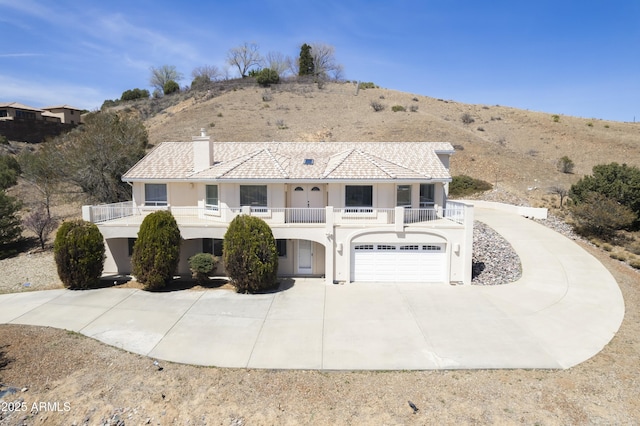 11430 E Manzanita Trl, Dewey, AZ 86327 - view of front of home with driveway, stucco siding, a balcony, a garage, and a chimney