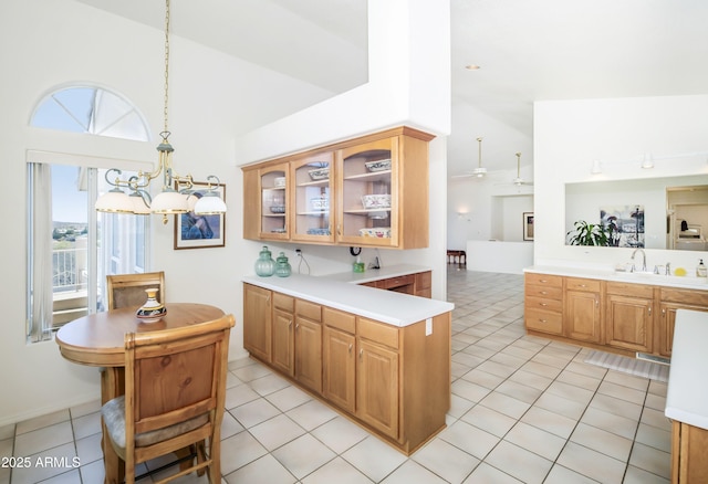 11430 E Manzanita Trl, Dewey, AZ 86327 - kitchen with light countertops, glass insert cabinets, a peninsula, high vaulted ceiling, and a chandelier
