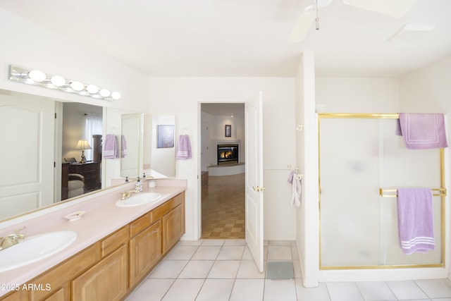 11430 E Manzanita Trl, Dewey, AZ 86327 - full bath with double vanity, a shower stall, a glass covered fireplace, tile patterned floors, and a ceiling fan