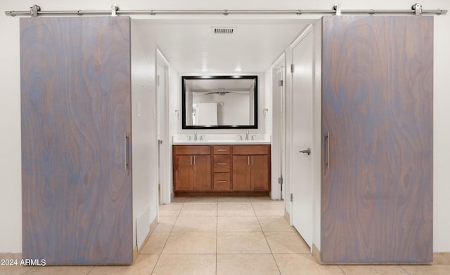 7012 N 22nd St, Phoenix, AZ 85020 - corridor featuring a barn door, light tile patterned floors, and sink