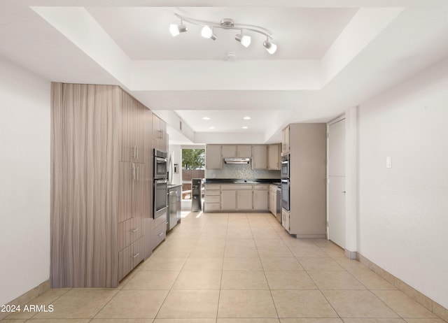 7012 N 22nd St, Phoenix, AZ 85020 - kitchen featuring decorative backsplash, light tile patterned floors, stainless steel double oven, and a tray ceiling