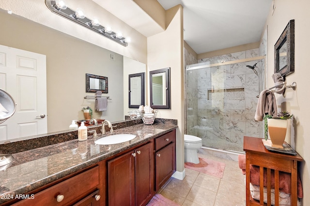 bathroom with tile patterned floors, vanity, toilet, and walk in shower