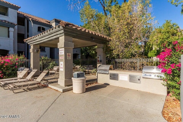 view of patio featuring a gazebo, grilling area, and exterior kitchen