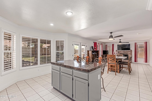 1723 W Mercury Way, Chandler, AZ 85224 - kitchen featuring light tile patterned flooring, crown molding, gray cabinets, a ceiling fan, and a center island