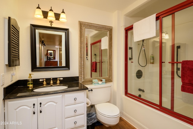 full bathroom featuring shower / bath combination with glass door, wood-type flooring, vanity, and toilet