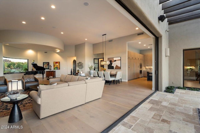 living room with a towering ceiling and light hardwood / wood-style floors