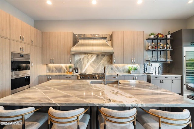 kitchen featuring double oven, custom exhaust hood, decorative backsplash, and a spacious island