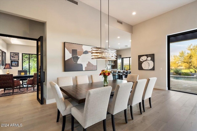 dining space with light hardwood / wood-style floors and a notable chandelier