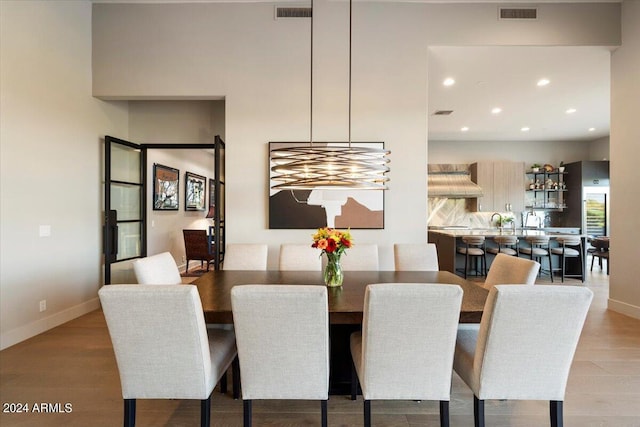 dining space featuring a chandelier, light wood-type flooring, and sink