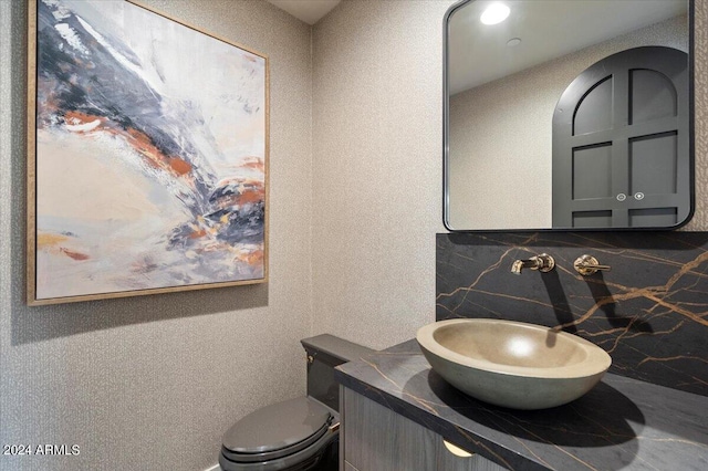 bathroom with decorative backsplash, vanity, tile walls, and toilet