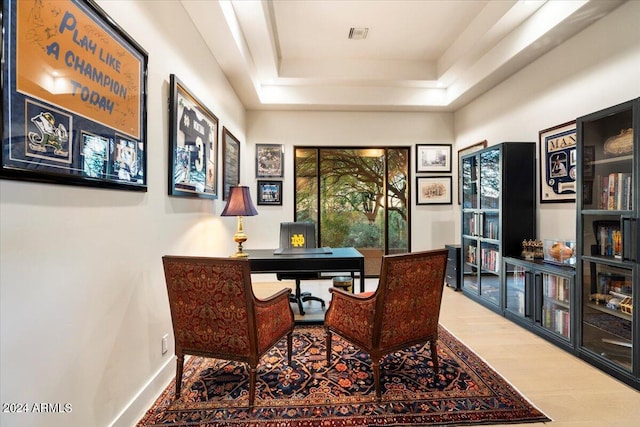 office with a tray ceiling and hardwood / wood-style floors