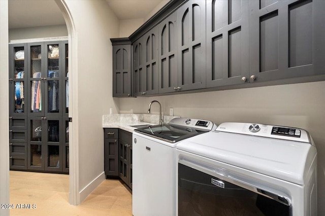 laundry room featuring cabinets, sink, and washing machine and dryer