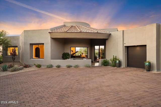 pueblo-style house featuring a garage