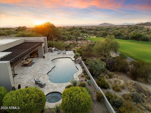 pool at dusk featuring a patio area and a hot tub