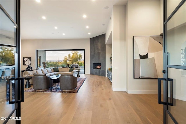 living room with a fireplace and light wood-type flooring