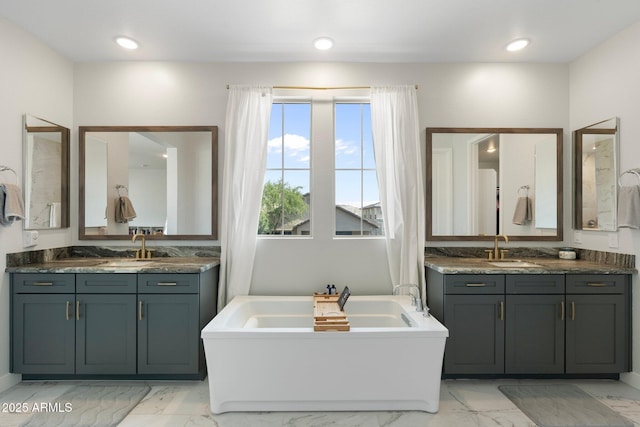 21134 W Minnezona Ave, Buckeye, AZ 85396 - full bath with marble look tiles, a freestanding bath, two vanities, and recessed lighting