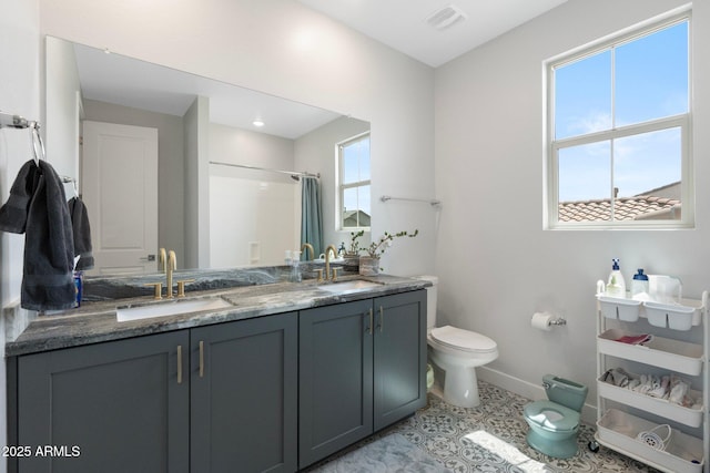 21134 W Minnezona Ave, Buckeye, AZ 85396 - bathroom featuring toilet, baseboards, a shower with curtain, and double vanity