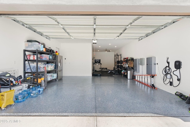 21134 W Minnezona Ave, Buckeye, AZ 85396 - garage featuring baseboards, a garage door opener, and stainless steel fridge with ice dispenser