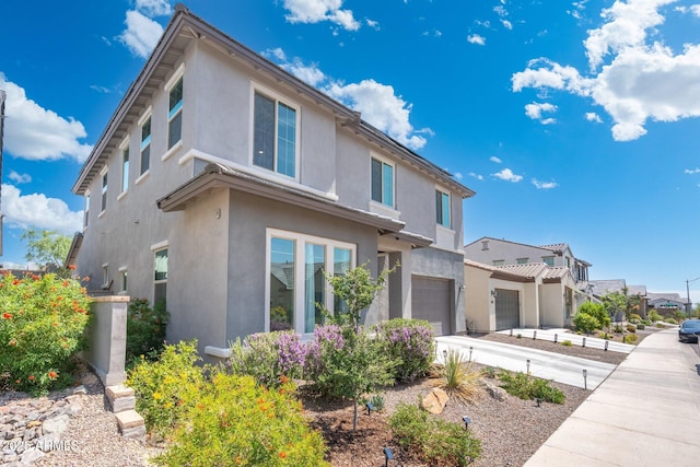 21134 W Minnezona Ave, Buckeye, AZ 85396 - view of front of property with stucco siding, an attached garage, and a residential view