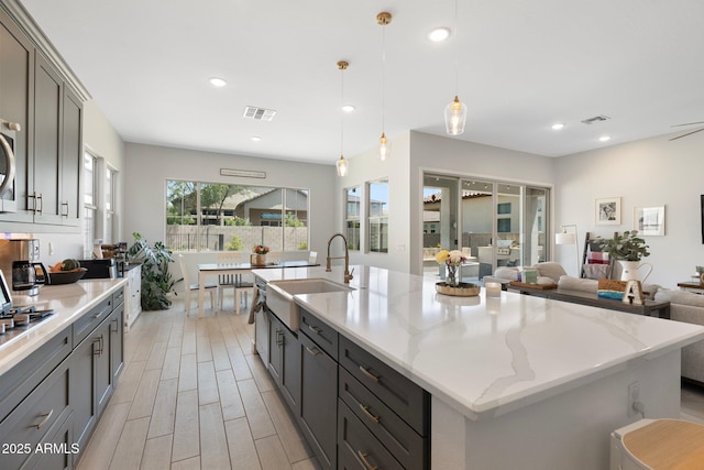 21134 W Minnezona Ave, Buckeye, AZ 85396 - kitchen featuring a sink, light wood-style flooring, gray cabinets, a spacious island, and recessed lighting