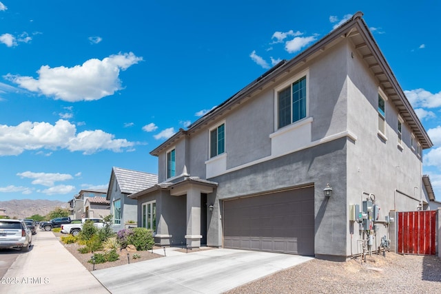 21134 W Minnezona Ave, Buckeye, AZ 85396 - view of front of property with an attached garage, stucco siding, driveway, and a mountain view