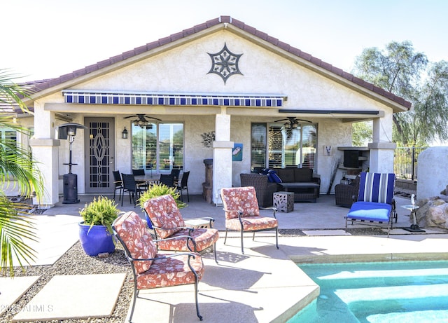 back of house featuring a ceiling fan, a patio area, an outdoor living space, and stucco siding