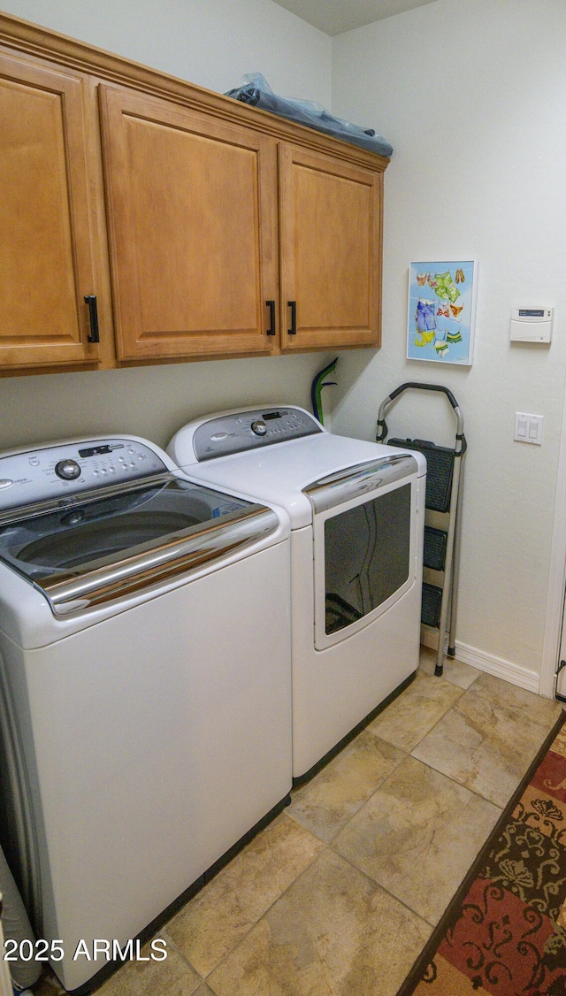 washroom featuring cabinet space, independent washer and dryer, and baseboards