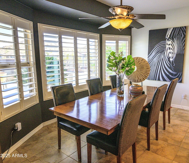 dining space with ceiling fan and baseboards