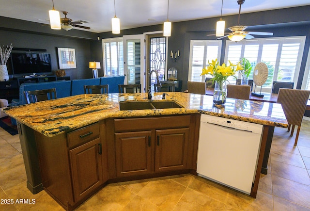 kitchen with dishwasher, open floor plan, a sink, and light stone countertops