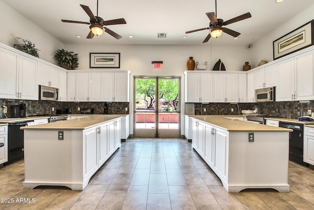 kitchen featuring black dishwasher, stainless steel microwave, and a kitchen island