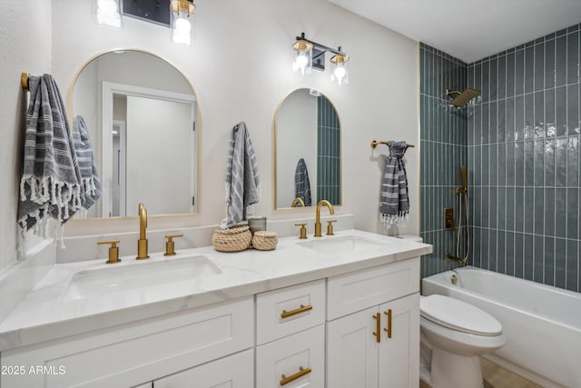 full bathroom with vanity, tiled shower / bath combo, and toilet