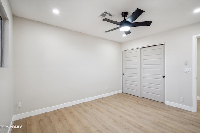 unfurnished bedroom featuring ceiling fan, light hardwood / wood-style floors, and a closet