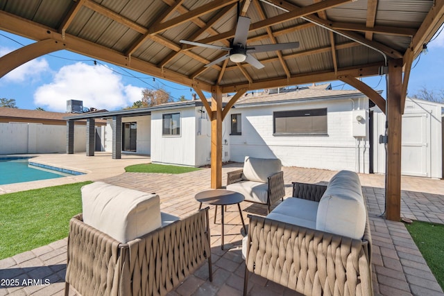 view of patio / terrace featuring a storage shed, a gazebo, ceiling fan, an outdoor hangout area, and a fenced in pool