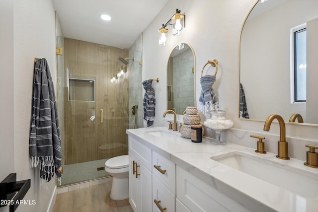 bathroom with vanity, toilet, a shower with door, and wood-type flooring