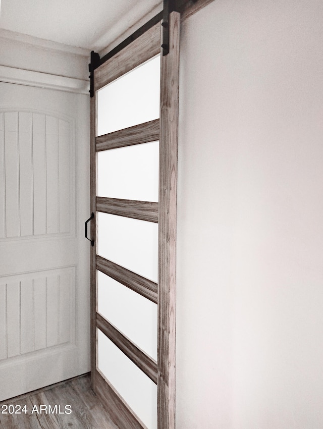 interior space with a barn door and hardwood / wood-style flooring