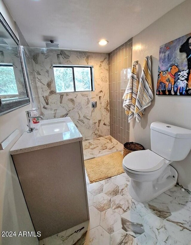 bathroom featuring vanity, toilet, and tiled shower