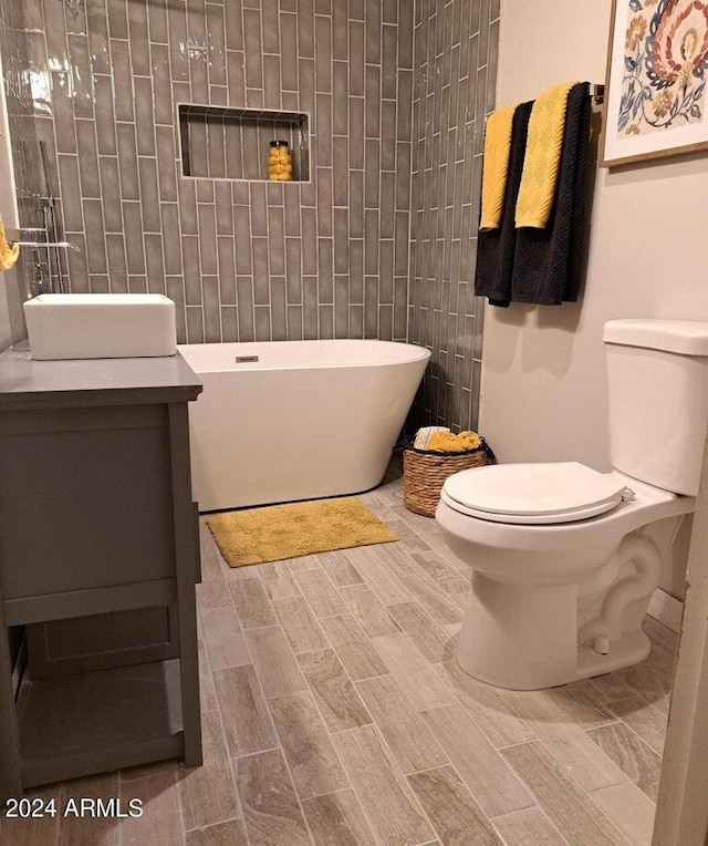 bathroom with vanity, toilet, and a bathing tub