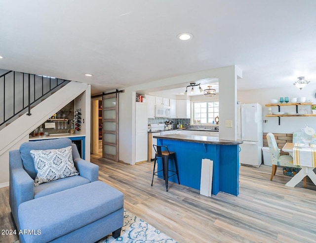 interior space with light hardwood / wood-style floors, sink, and a barn door