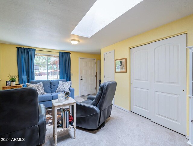 carpeted living room with a skylight