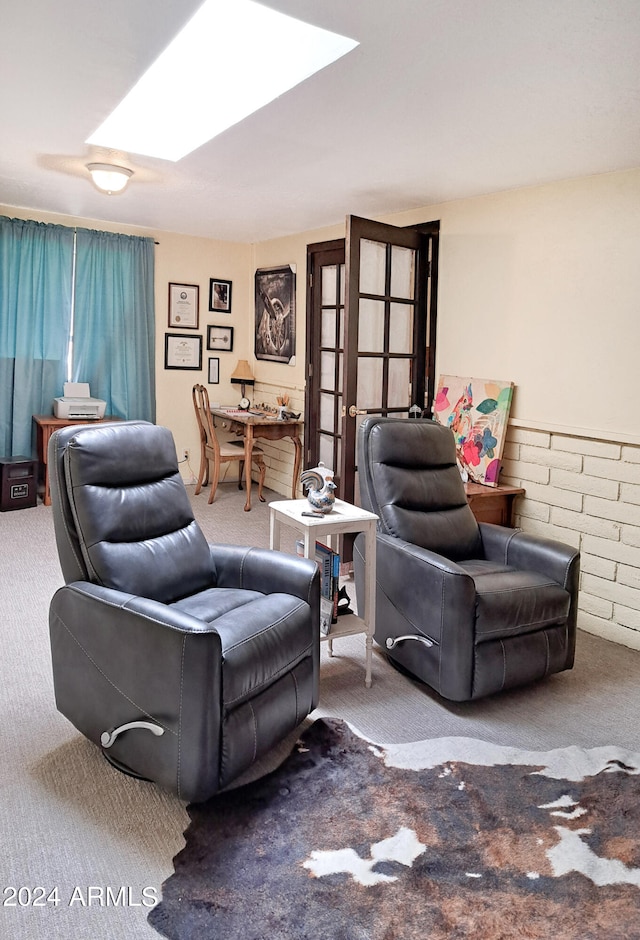 carpeted living room featuring a skylight