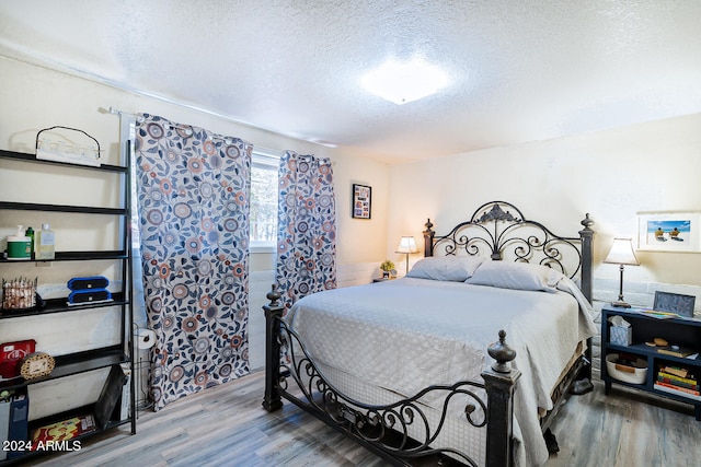 bedroom featuring wood-type flooring and a textured ceiling