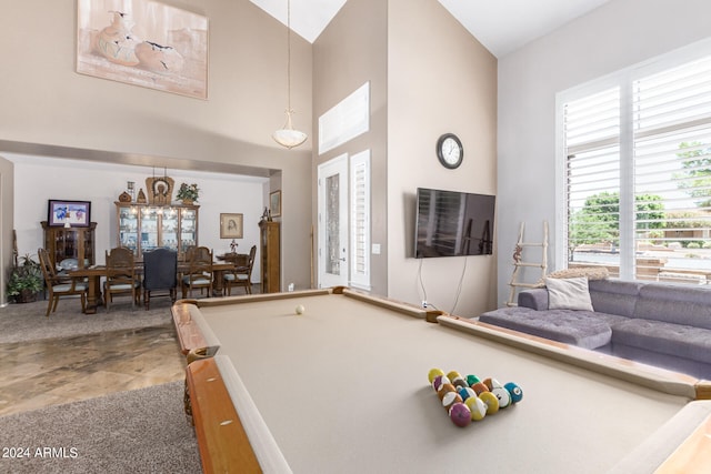 game room featuring a towering ceiling, pool table, and a notable chandelier