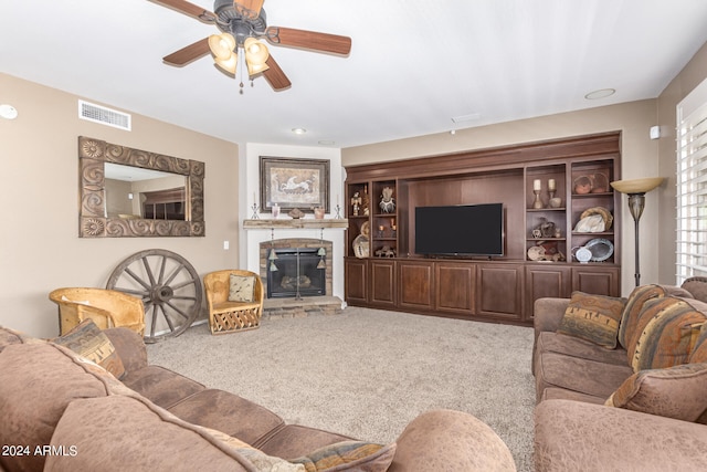 carpeted living room with ceiling fan and a fireplace