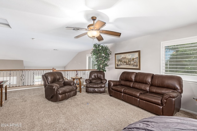 carpeted living room with ceiling fan and vaulted ceiling